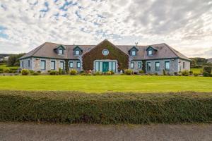 una casa grande con un gran césped verde en Like walking into a fantastic novel at Inishowen House, en Rashenny