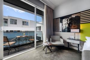 a bedroom with a balcony with a bed and a table at Hotel Lero in Dubrovnik