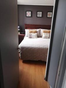 a bedroom with a bed with white sheets and pillows at Amplió, cómodo y amoblado departamento, La Florida in Santiago