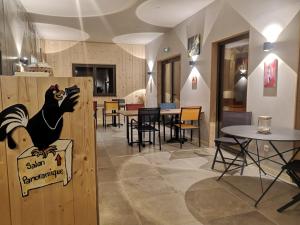 a restaurant with a chicken sign on a wooden wall at Aux Buis Gourmands in La Chapelle-en-Vercors