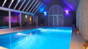 a swimming pool with blue lights in a house at Dionbulles & Dionlodge Guesthouse and not included private wellness in Chaumont-Gistoux