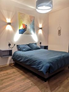 a bedroom with a bed and a painting on the wall at Aux Buis Gourmands in La Chapelle-en-Vercors