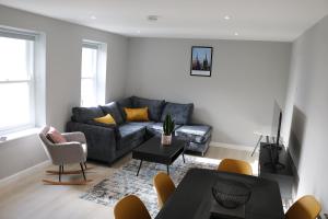 uma sala de estar com um sofá e uma mesa em Church Suites Enniskillen em Enniskillen