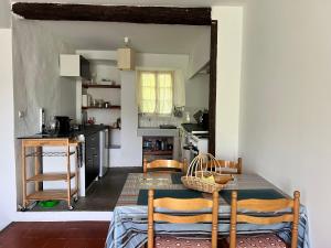 cocina con mesa y sillas en una habitación en La Roseraie - Gite avec piscine en Cévennes, en Roquedur
