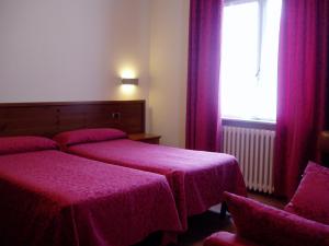 Rúm í herbergi á Albergo Delle Alpi