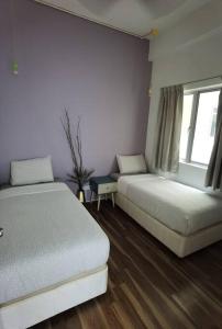 a bedroom with two beds and a window at G Residence - 2BR Family Suite Barrington Night Market - 4 in Brinchang