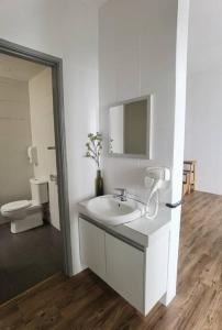 a white bathroom with a sink and a toilet at G Residence - 2BR Family Suite Barrington Night Market - 4 in Brinchang