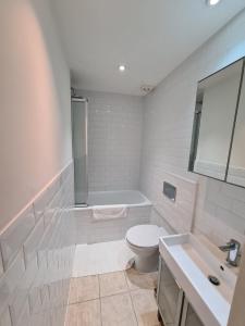 a bathroom with a toilet and a tub and a sink at Baker Street Central Apartments in London