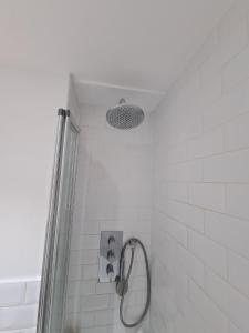 a shower with a shower head in a bathroom at Baker Street Central Apartments in London