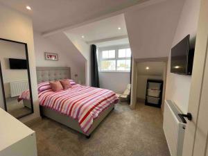 a bedroom with a large bed and a mirror at Cranford House 3 bedroom apartment Filey in Filey