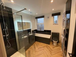 a bathroom with a shower and a tub and a toilet at Cranford House 3 bedroom apartment Filey in Filey