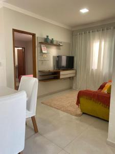 a living room with a bed and a tv in it at Casa Prado Bahia in Prado