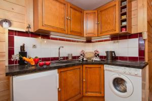 里雾诗Résidence Le Château - D86 - Happy Rentals的厨房配有木制橱柜和洗衣机。
