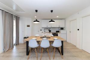 Il comprend une cuisine et une salle à manger avec une table et des chaises en bois. dans l'établissement Family apartments Zadar, à Zadar