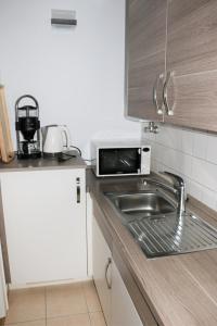 a kitchen with a sink and a microwave at 2Zi-App Nähe Hbf und Aalto Theater mit kl. Balkon in Essen