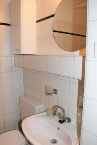 ein Badezimmer mit einem Waschbecken, einem WC und einem Spiegel in der Unterkunft 2Zi-App Nähe Hbf und Aalto Theater mit kl. Balkon in Essen