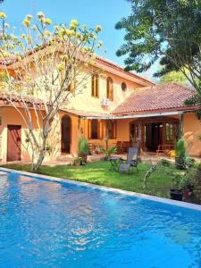 a house with a swimming pool in front of a house at Wonderful Villa Felice in Yogyakarta