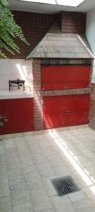 a red garage with a red door on a building at Departamento Villa Nueva in Villa María