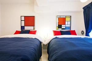 twee bedden in een kamer met twee ramen bij ダイトービル304 in Tokyo