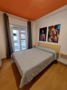 a bedroom with a bed and two pictures on the wall at Arc House Granada in Granada