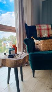 sala de estar con sofá y mesa con tijeras en WoodStone Apartments Karpacz, en Karpacz