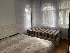 two beds in a bedroom with two windows at Side home beach in Side