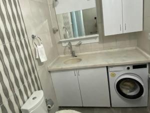 a bathroom with a sink and a washing machine at Side home beach in Side