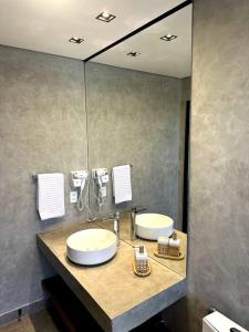 a bathroom with two sinks and a large mirror at Casa Vértize, uma casa de alto padrão com Spa Hidro e vista espetacular in Cavalcante