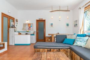 a living room with a couch and a kitchen at Ticket2Surf in Palheiros da Tocha