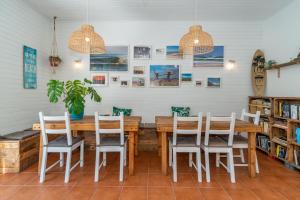 a dining room with a wooden table and chairs at Ticket2Surf in Palheiros da Tocha