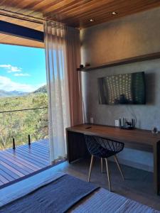 Zimmer mit einem Schreibtisch und einem Fenster mit Aussicht in der Unterkunft Casa Vértize, uma casa de alto padrão com Spa Hidro e vista espetacular in Cavalcante