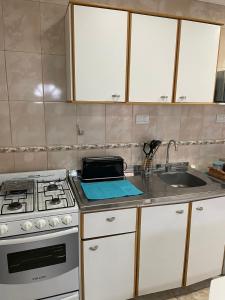 cocina con fogones y fregadero en Mara Patagónica - Apartments en Río Gallegos