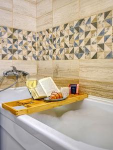 a bath tub with a plate of food and a glass of wine at Green Boutique - квартира в изумрудных оттенках на Мынбаева in Almaty