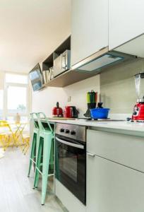 a kitchen with a stove and some green stools at Departamento Zurich en Temuco in Temuco