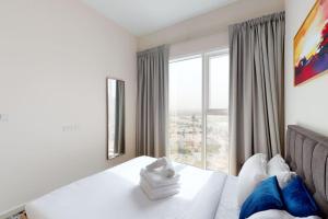 a bedroom with a bed and a large window at Key View - Golf Vita in Dubai Marina