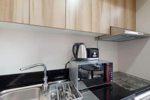 a kitchen with a sink and a microwave at Key View - Golf Vita in Dubai Marina