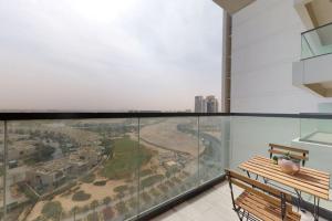 a glass balcony with a bench and a view of a city at Key View - Golf Vita in Dubai Marina