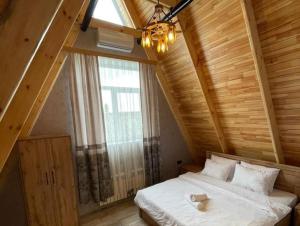a bedroom with a bed with a large window at Qafqaz Eminent Chalet in Gabala