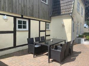 a patio with a table and chairs and a building at Ferienhaus Alte Mühle in Stoltebüll