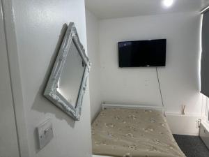 3bed Rooms Apartment Terrace في كريستال بالاس: مرآة وتلفزيون في غرفة بيضاء