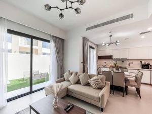 ein Wohnzimmer mit einem Sofa und einem Tisch in der Unterkunft StoneTree - 3 BR with 1 Maids Room Villa in Camelia - Arabian Ranches in Dubai