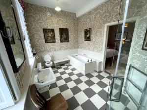 a bathroom with a tub and a toilet and a sink at Blyth Hall in Coleshill