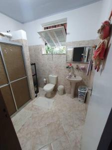 La salle de bains est pourvue de toilettes et d'un lavabo. dans l'établissement Chácara Sombra da Mangueira - 150 Mts da Praia, à Itaparica Town