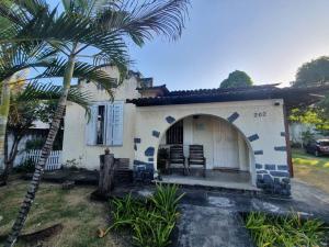 une maison avec un palmier en face dans l'établissement Chácara Sombra da Mangueira - 150 Mts da Praia, à Itaparica Town