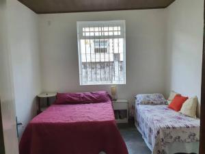 - une chambre avec 2 lits et une fenêtre dans l'établissement Chácara Sombra da Mangueira - 150 Mts da Praia, à Itaparica Town