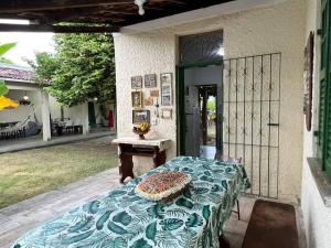 une table assise à l'extérieur d'une maison avec une table sidx sidx sidx dans l'établissement Chácara Sombra da Mangueira - 150 Mts da Praia, à Itaparica Town