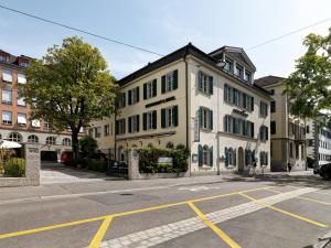- un bâtiment blanc avec des fenêtres noires dans une rue dans l'établissement Hotel St. Josef, à Zurich