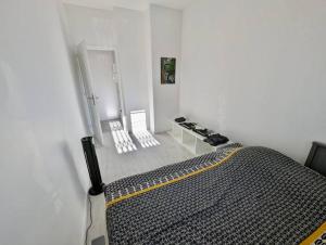 a bedroom with a bed in a white room at Magnifique T2 refait à neuf - Calme & Tout Equipé avec Parking in Grenoble
