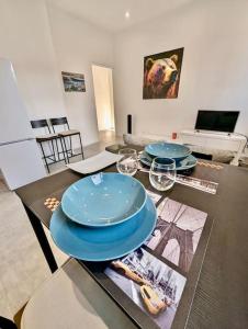 a table with two blue plates on it in a living room at Magnifique T2 refait à neuf - Calme & Tout Equipé avec Parking in Grenoble