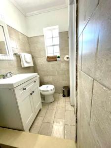 a bathroom with a toilet and a sink and a window at 2q Suite Apt W Shared Pool 10 To Beach 05 in Clearwater